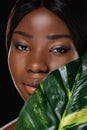 African woman with green exotic leaf