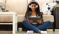 African american woman in headphones looking at digital tablet at home Royalty Free Stock Photo