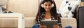 African american woman in headphones looking at digital tablet at home Royalty Free Stock Photo