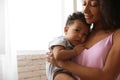 African-American woman her baby at home. Happiness of motherhood