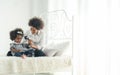 African-American woman and her baby with phone in bed. Happiness of motherhood Royalty Free Stock Photo