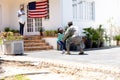 African American woman and her daughter standing welcoming an African American soldier