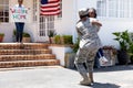 African American woman and her daughter standing welcoming an African American soldier