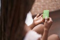 African american woman holding birth control pills sitting on bed at bedroom Royalty Free Stock Photo