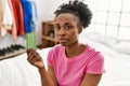 African american woman holding birth control pills sitting on bed at bedroom Royalty Free Stock Photo