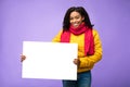 African American Woman Holding Blank Board Posing Over Purple Background Royalty Free Stock Photo
