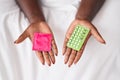 African american woman holding condom and birth control pills at bedroom Royalty Free Stock Photo