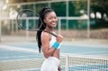 African american woman holding her tennis racket on the court. Young girl ready for a tennis match outside. Smiling Royalty Free Stock Photo