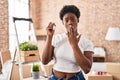 African american woman holding keys of new home covering mouth with hand, shocked and afraid for mistake Royalty Free Stock Photo