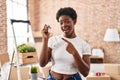 African american woman holding keys of new home smiling happy pointing with hand and finger Royalty Free Stock Photo