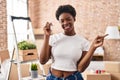 African american woman holding keys of new home smiling happy pointing with hand and finger to the side Royalty Free Stock Photo