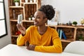 African american woman holding led light bulb sitting on table at home Royalty Free Stock Photo