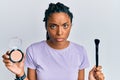 African american woman holding makeup brush and blush skeptic and nervous, frowning upset because of problem