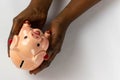 African American woman holding piggy bank with Nigerian Naira in white background