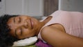 African American woman lies on prickly mat to massage back