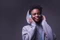 An African-American woman listening to music with headphones. A young woman wearing headphones smiles, looks directly Royalty Free Stock Photo