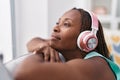 African american woman listening to music relaxed on sofa at home