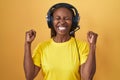 African american woman listening to music using headphones excited for success with arms raised and eyes closed celebrating Royalty Free Stock Photo