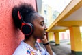 African American woman listens to music with headphones on the street Royalty Free Stock Photo