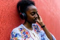 African American woman listens to music with headphones on the street Royalty Free Stock Photo