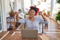 African american woman listneing to music sitting on table at home terrace Royalty Free Stock Photo