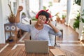 African american woman listneing to music sitting on table at home terrace Royalty Free Stock Photo