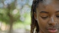 African american woman looking down with serious expression at park Royalty Free Stock Photo