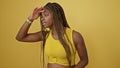 African american woman looking to the side far away over isolated yellow background Royalty Free Stock Photo