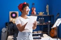 African american woman musician composing song writing on paper at music studio