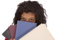 African American woman peaking from behind books