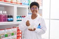 African american woman pharmacist mixing product working at pharmacy