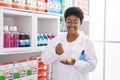 African american woman pharmacist mixing product working at pharmacy