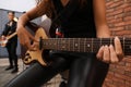 African American woman playing electric guitar during rehearsal in studio, closeup. Music band practice Royalty Free Stock Photo