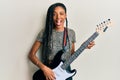 African american woman playing electric guitar winking looking at the camera with sexy expression, cheerful and happy face Royalty Free Stock Photo