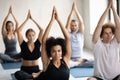 African American woman practicing yoga at group lesson, Padmasana exercise