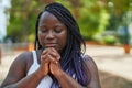 African american woman praying with closed eyes at park Royalty Free Stock Photo