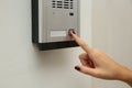 African-American woman pushing intercom button in entryway, closeup Royalty Free Stock Photo
