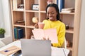 African american woman reading book and drinking coffee at home Royalty Free Stock Photo