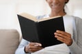 African American woman reading book relaxing at home Royalty Free Stock Photo