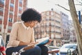 African American woman reading a book sitting on a bench. Latina woman with a book. Royalty Free Stock Photo