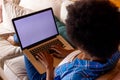 African american woman relaxing on sofa using laptop with copy space on screen at home Royalty Free Stock Photo