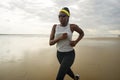 African American woman running on the beach - young attractive and athletic black girl training outdoors doing jogging workout at Royalty Free Stock Photo