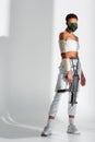 African american woman in safety mask with assault rifle on white background