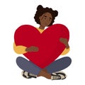 African American woman seating holding a heart in her hands.