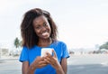 African american woman sending message with phone Royalty Free Stock Photo