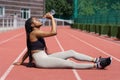 African American woman sitting in stadium drinking a lot of water from bottle after intense workout. Royalty Free Stock Photo