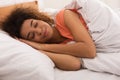 African-american woman sleeping sweetly on bed at home