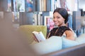 African American woman smiling at camera while reading a book Royalty Free Stock Photo