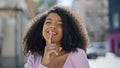 African american woman smiling confident doing silent gesture at street