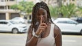 African american woman smiling confident doing silent gesture at street